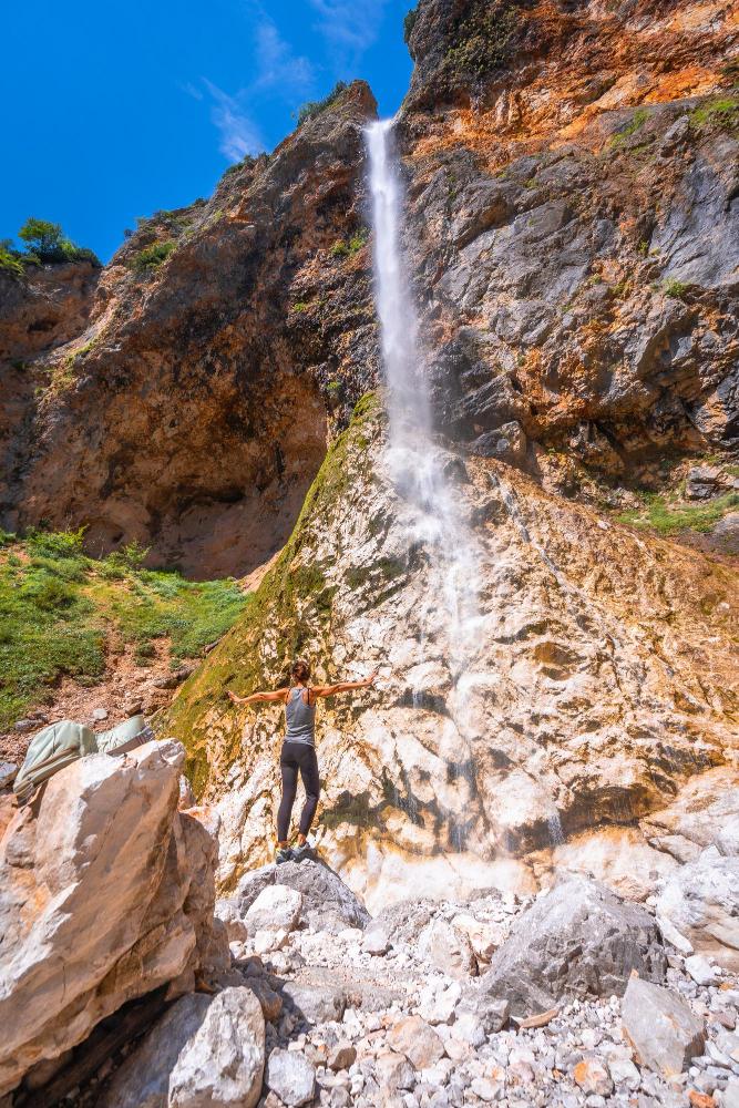 Hiker admiring rinka waterfall in logarska dolina valley slovenia