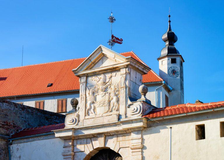 Church clock tower and entrance gate in ptuj castle in slovenia